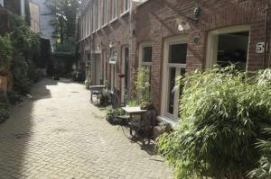 アムステルダムにあるBeautiful 2 floor Vondelpark apartment.のレンガ造りの建物で、中庭(ベンチ付)が隣接しています。