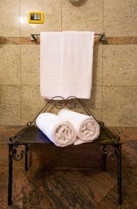 einen Handtuchhalter mit Handtüchern und Handtüchern im Bad in der Unterkunft Hotel e Locanda La Bastia in Valeggio sul Mincio