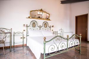 a bedroom with a white bed and a mirror at Hotel e Locanda La Bastia in Valeggio sul Mincio