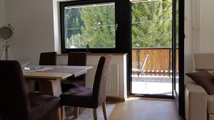 a dining room with a table and chairs and a balcony at Apartment Alpska Astra in Kranjska Gora
