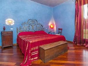 1 dormitorio con cama roja y paredes azules en B&B La Colombera, en Lessona