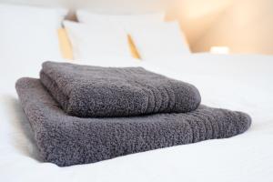 a gray towel sitting on top of a bed at Apartment mit Dachterrasse & Sauna in Wangen im Allgäu