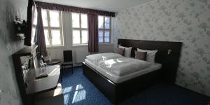 um pequeno quarto com uma cama e uma janela em Hotel Alte Brennerei em Wernigerode