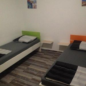 Habitación con 2 camas y 2 mesas. en Rooms Chill Out Beach en Trogir