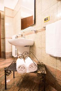 a bathroom with a sink and a toilet and towels at Hotel e Locanda La Bastia in Valeggio sul Mincio