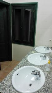 two white sinks in a bathroom with a mirror at Albergue de San Blas in Tragacete
