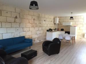 a living room with a blue couch and a table at Chateau La Fontaine in Fronsac