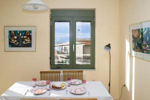 een tafel met borden eten erop met een raam bij Modern House with Sea View in Chania