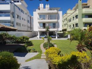 un jardín frente a un edificio con palmeras en IDP204- APARTAMENTO DE 2 DORMITORIOS NO INGLESES, en Florianópolis