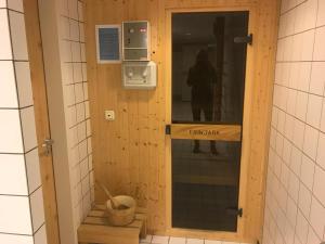eine Tür im Bad mit einer Person im Spiegel in der Unterkunft Steiner Strandappartements Appartement 308 Süd- Landseite in Stein