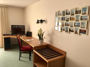 Zimmer mit einem Schreibtisch mit einem Computer und Bildern an der Wand in der Unterkunft Steiner Strandappartements Appartement 308 Süd- Landseite in Stein