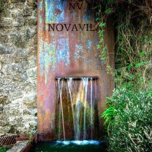 una fuente de agua oxidada en el lateral de un edificio en Enoturismo Novavila Rias Baixas Wine Design en Meis