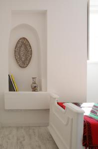 une chambre blanche avec une plaque sur le mur dans l'établissement Casa de Baixo, à Coimbra