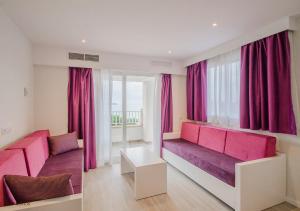 a living room with pink and purple furniture at Apartamentos Ponent in Paguera