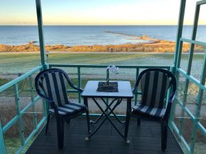 a table and two chairs on a balcony with the ocean at Steiner Strandappartements Appartement 302 Seeseite in Stein