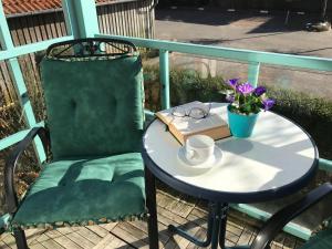 a table with a chair and a cup and a book at Steiner Strandappartements Appartement 106 Süd- Landseite in Stein