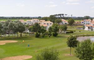 a person flying a kite on a golf course at Madame Vacances Les Appartements de Fontenelles in LʼAiguillon-sur-Vie