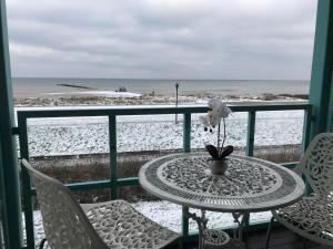 a table and chairs on a balcony with the beach at Steiner Strandappartements Studio-Appartement 203 Seeseite in Stein +7 photos