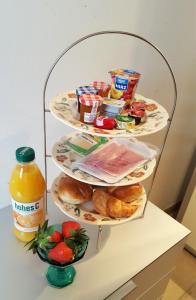 a three tiered shelf with food and a bottle of orange juice at Suite mit Parkplatz Gebertingen in Gebertingen