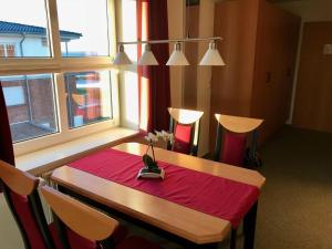 a table with a red table cloth and a window at Steiner Strandappartements Appartement 310 Südseite mit seitlichem Meerblick in Stein +4 photos
