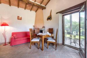 sala de estar con sofá rojo y mesa en La casina degli olivi, en Seggiano
