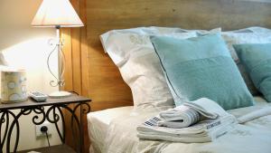 Una cama con almohadas azules y toallas. en Palais des Papes - Havre de Paix III en Aviñón