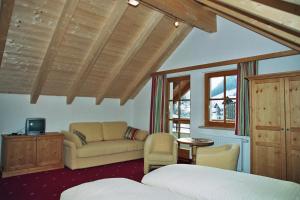 a bedroom with a bed and a couch at Hotel Garni Litzner in Ischgl