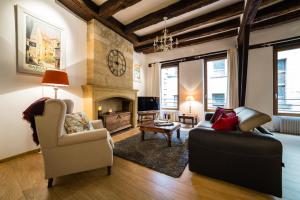 ein Wohnzimmer mit Couch und Kamin in der Unterkunft Duplex Cité Médiévale Sarlat in Sarlat-la-Canéda