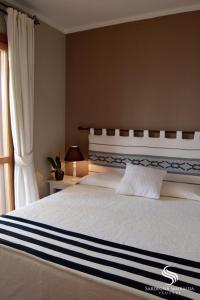 una camera con un grande letto e una finestra di Villaggio Smeralda by Sardegna Smeralda Suite a Porto Rotondo