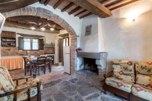 uma cozinha e sala de estar com lareira de pedra em La villa della quercia em Seggiano