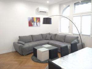 a living room with a gray couch and a table at Avenue de La Paix - L'Exclusif in Strasbourg