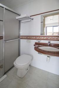 a bathroom with a toilet and a sink at Hotel Kimar in Tramandaí