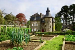 een oud kasteel met een tuin ervoor bij Chambres d'hôtes Manoir Ker-Huella in Morlaix