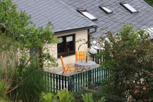 een klein huis met een tafel en stoelen op een veranda bij Ferienwohnung Glaser in Sebnitz