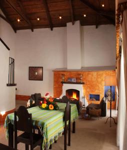 a living room with a table and a fireplace at Antigua Guatemala Villas in Antigua Guatemala