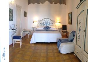 a bedroom with a white bed and two chairs at Hotel Villa Delle Palme in Positano in Positano