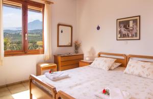 a bedroom with a bed and a window at Plakias Villas in Lefkogeia