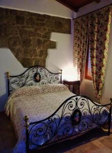 ein Schlafzimmer mit einem Bett mit einer Steinwand in der Unterkunft La casa di Susanna in Viterbo