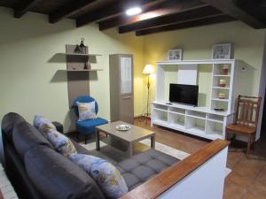 - un salon avec un canapé et une télévision dans l'établissement La Quintana de Ribadesella, à Ribadesella