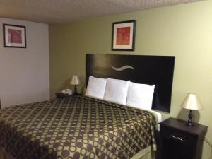 Habitación de hotel con 1 cama y 2 mesitas de noche en Americas Best Value Inn Kansas City East - Independence, en Independence