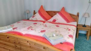 ゼープニッツにあるFerienwohnung Glaserのベッド(ピンクと白のシーツ、赤の枕付)