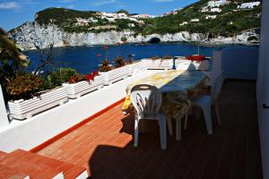 een tafel en stoelen op een balkon met uitzicht op de oceaan bij Maridea - Donatino a Mare in Ponza