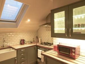a kitchen with a sink and a microwave at Manhattan loft in Margate