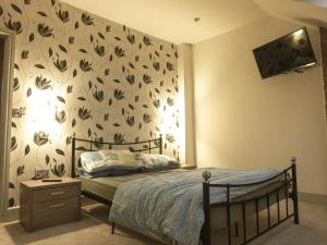 a bedroom with a bed with a floral wallpaper at Manhattan loft in Margate