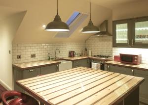 a large kitchen with a wooden table in it at Manhattan loft in Margate