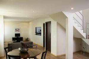 ein Wohnzimmer mit einem Tisch und einer Treppe in der Unterkunft Piemonte Hotel in Nova Lima