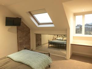 a bedroom with a bed and a skylight at Manhattan loft in Margate