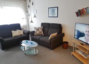 Una sala de estar con dos sofás y un televisor. en Harzburger Ferienwohnung, en Bad Harzburg