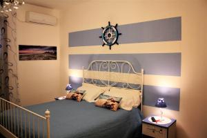 1 dormitorio con 1 cama con reloj en la pared en Oasi Del Gabbiano, en Siracusa
