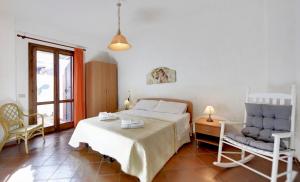 ein Schlafzimmer mit einem Bett und einem Stuhl in der Unterkunft Villa dell'Ulivo in Marina di Ragusa